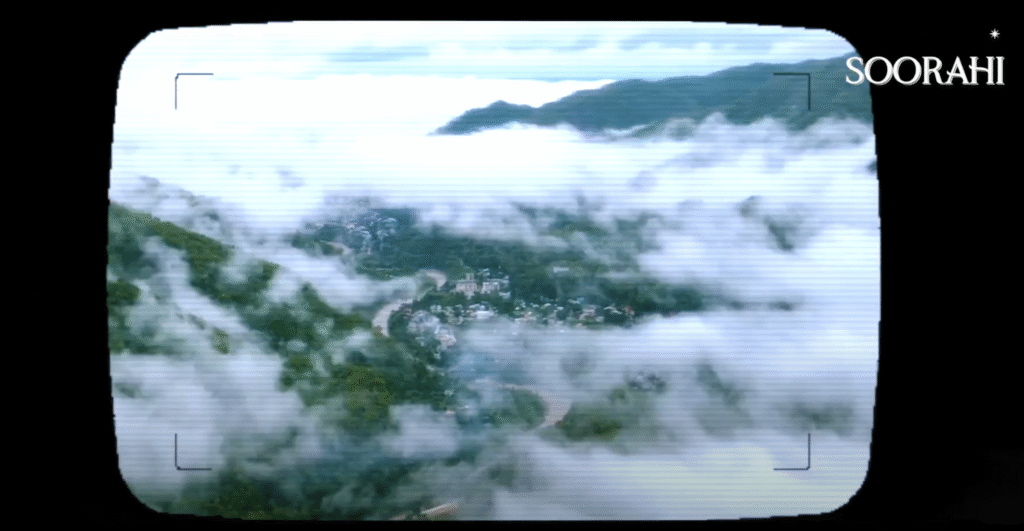 Aerial view of Indian mountains and valleys seen through a vintage video camera frame, with clouds drifting over the landscape and the Soorahi logo in the corner, reflecting the brand’s “Spirit of Discovery” campaign.