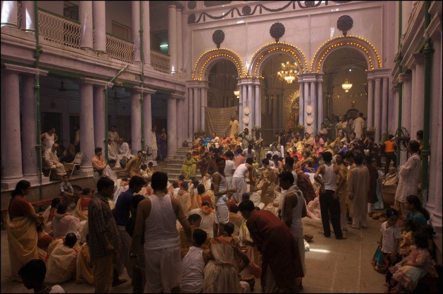 "Split image showing traditional Bengali Durga Puja celebration in ornate pandal with multigenerational devotees contrasted with peaceful Darjeeling toy train journey through green hills