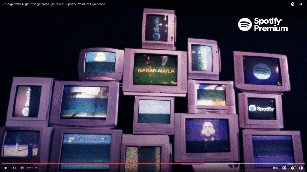 A striking display of stacked vintage television screens showing Spotify branding and the artist’s name, creating a retro yet modern concert backdrop.
