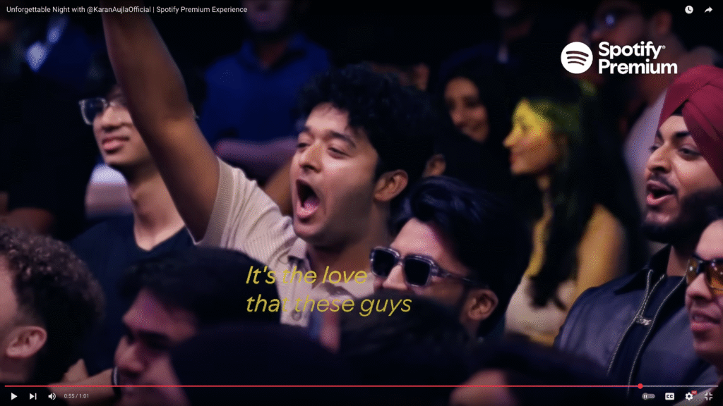 A lively audience member at a Spotify Premium live show, raising a hand to participate during the event.
