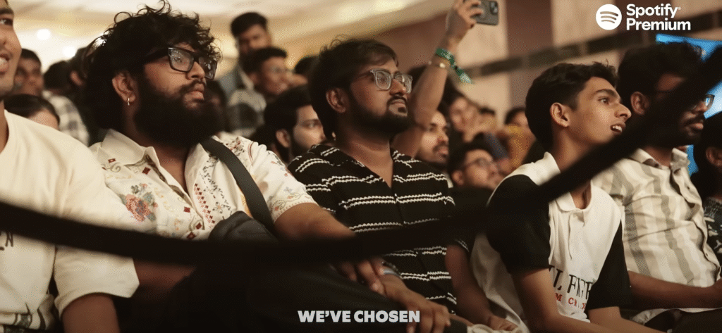 Excited concertgoers seated and awaiting the start of a Spotify Premium exclusive show, with visible anticipation and phones ready to capture the experience.
