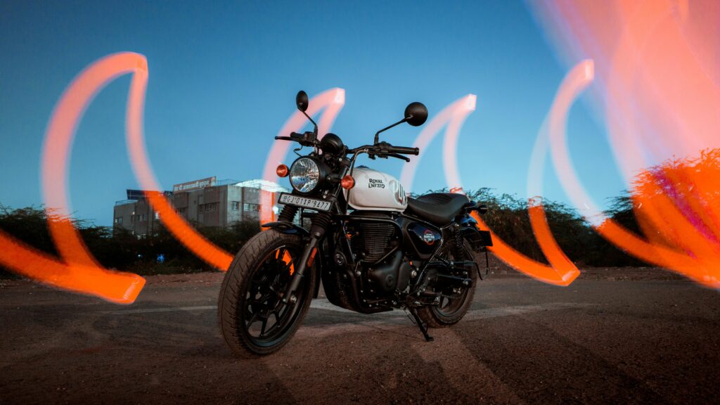 Captivating shot of a Royal Enfield motorcycle with dynamic light trails at dusk in Ahmedabad, India.