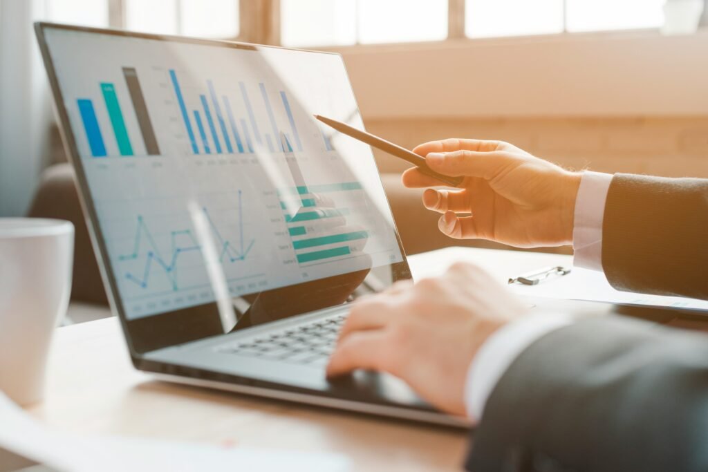 Business executive reviewing financial charts on a laptop during an AI investment decision.